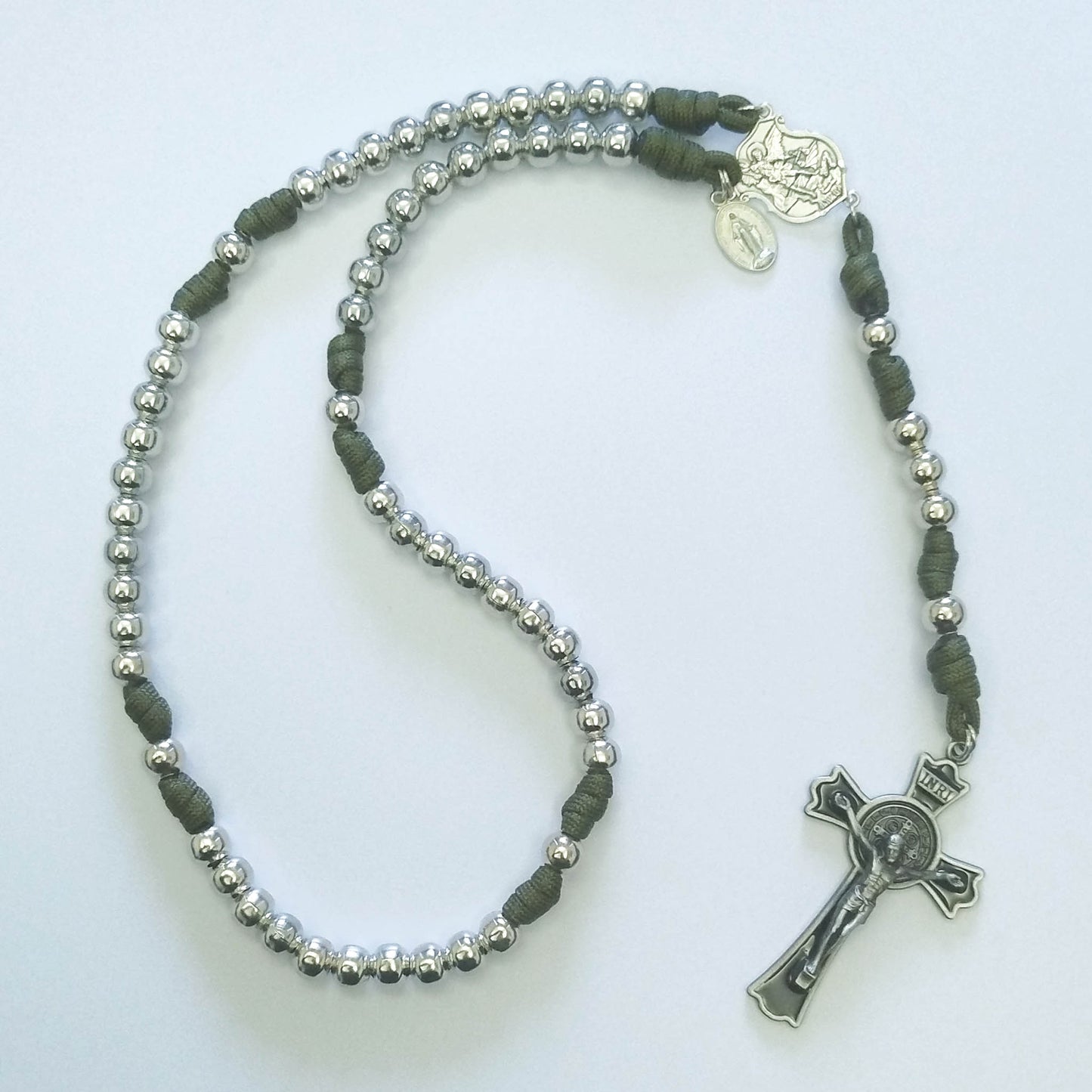 Rosary with green and silver beads on a white background